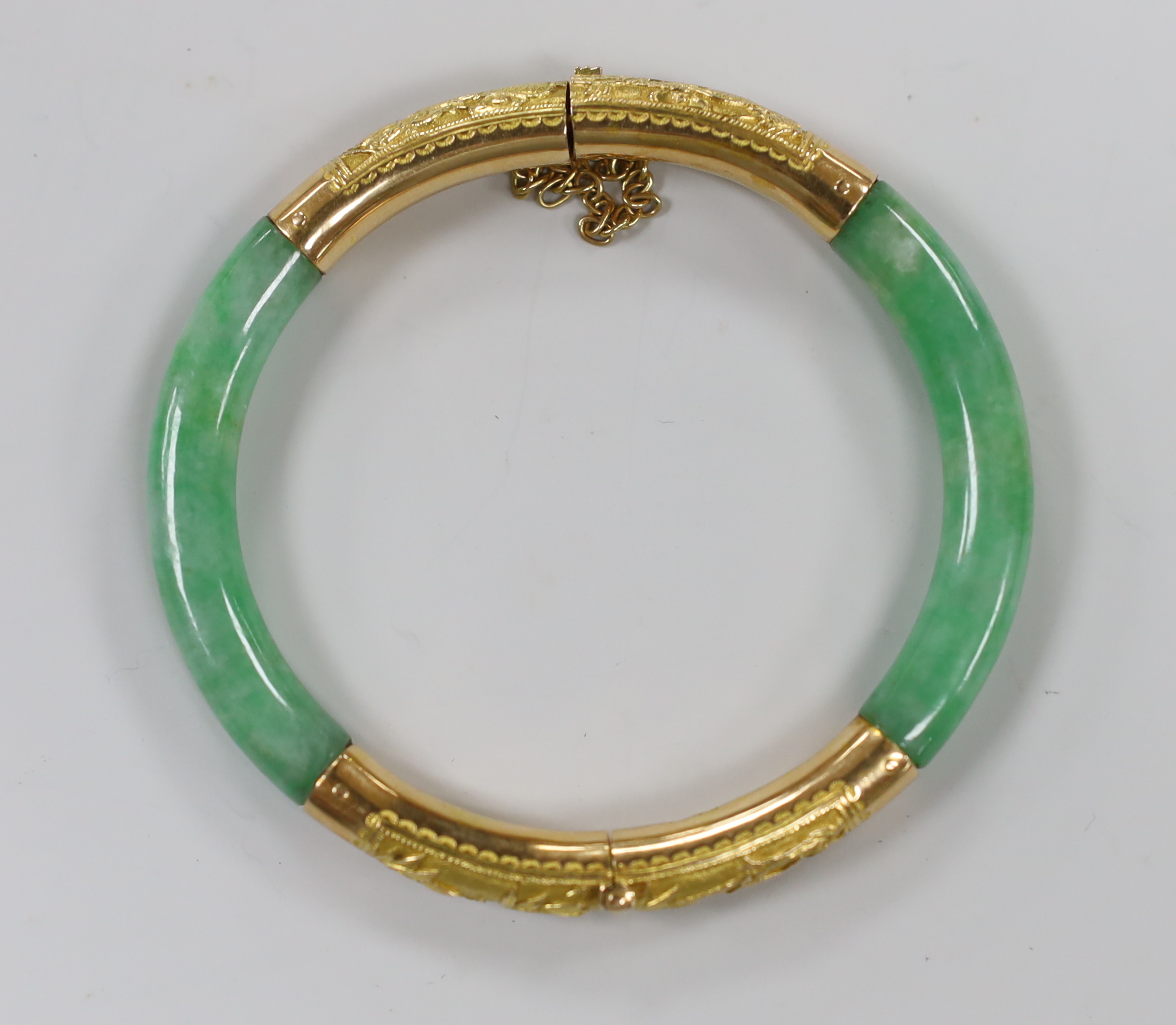 A Chinese 18k yellow metal mounted hinged bangle, interior diameter 57mm, gross weight 29.5 grams.